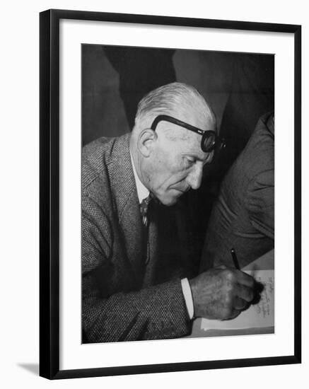 Swiss Architect Le Corbusier Leaning Down to Write with His Glasses Pushed Back on His Forehead-null-Framed Photographic Print