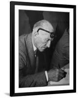 Swiss Architect Le Corbusier Leaning Down to Write with His Glasses Pushed Back on His Forehead-null-Framed Photographic Print