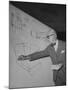 Swiss Architect Le Corbusier Standing on Stage with Notes in His Hand and Drawing on Sketch Pad-null-Mounted Photographic Print