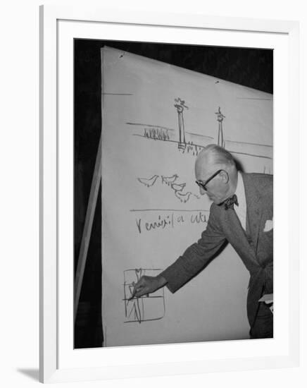 Swiss Architect Le Corbusier Standing on Stage with Notes in His Hand and Drawing on Sketch Pad-null-Framed Photographic Print