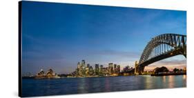 Sydney's iconic buildings lit up as dusk settles over the city, Sydney, New South Wales, Australia-Logan Brown-Stretched Canvas