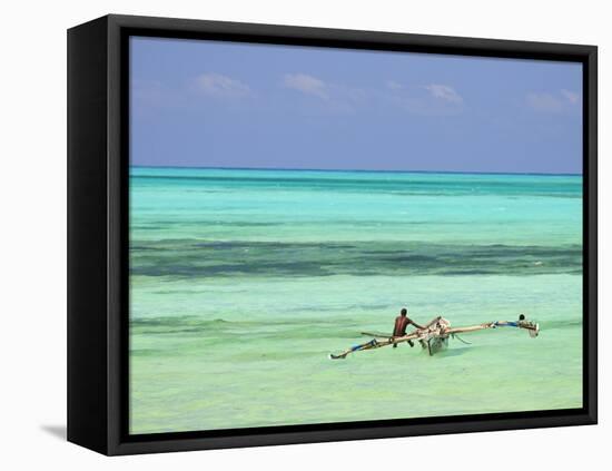 Tanzania, Zanzibar, Unguja, Jambiani, a Man Sits on His Boat Near the Shore-Nick Ledger-Framed Stretched Canvas