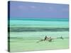 Tanzania, Zanzibar, Unguja, Jambiani, a Man Sits on His Boat Near the Shore-Nick Ledger-Stretched Canvas