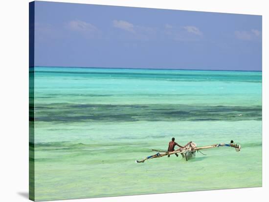 Tanzania, Zanzibar, Unguja, Jambiani, a Man Sits on His Boat Near the Shore-Nick Ledger-Stretched Canvas