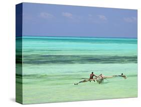 Tanzania, Zanzibar, Unguja, Jambiani, a Man Sits on His Boat Near the Shore-Nick Ledger-Stretched Canvas