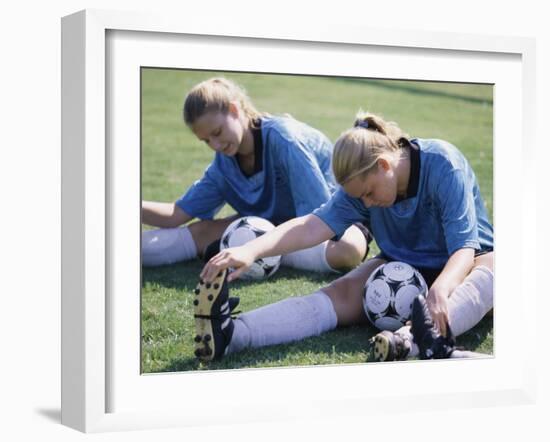Teenage Girls in Soccer Uniforms Doing Stretching Exercises-null-Framed Premium Photographic Print