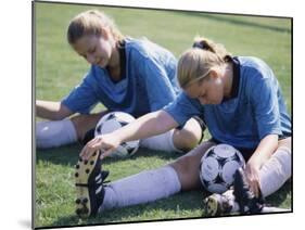 Teenage Girls in Soccer Uniforms Doing Stretching Exercises-null-Mounted Photographic Print