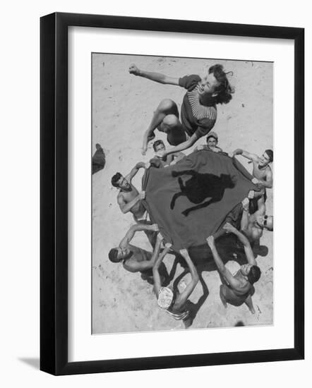 Teenaged Boys Using Blanket to Toss Their Friend, Norma Baker, Into the Air on the Beach-John Florea-Framed Photographic Print