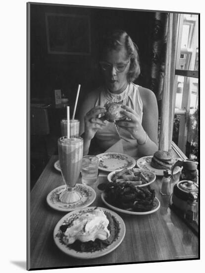 Teenaged Girl Sitting in Drugstore Eating a Hamburger-Hank Walker-Mounted Photographic Print