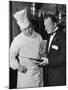 The 21 Club's Jack Kriendler Wearing a Tuxedo and Conferring with a Chef in the Club's Kitchen-null-Mounted Photographic Print