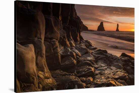 The basalt rock formations in the sea on Reynisfjara Beach in Vik, Iceland at sunrise.-Alex Saberi-Stretched Canvas