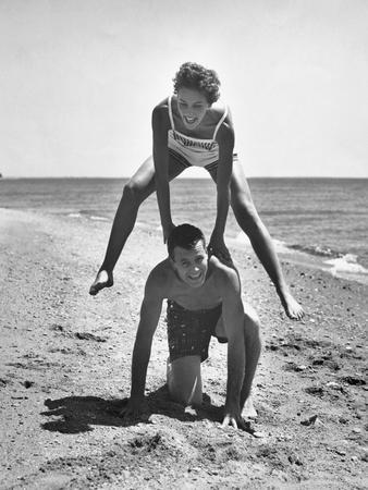 Young Couple Playing Leapfrog on the Beach