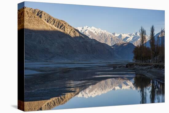 The crystal clear Shyok River creates a mirror image in the Khapalu valley near Skardu, Pakistan-Alex Treadway-Stretched Canvas