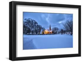 The illuminated church at dusk in the cold snowy landscape at Flakstad Lofoten Norway Europe-ClickAlps-Framed Photographic Print