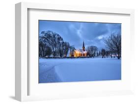 The illuminated church at dusk in the cold snowy landscape at Flakstad Lofoten Norway Europe-ClickAlps-Framed Photographic Print