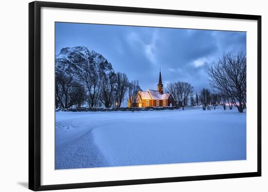 The illuminated church at dusk in the cold snowy landscape at Flakstad Lofoten Norway Europe-ClickAlps-Framed Photographic Print