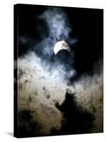 The Moon Partially Covers the Sun Behind the Clouds During a Partial Solar Eclipse-null-Stretched Canvas