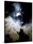 The Moon Partially Covers the Sun Behind the Clouds During a Partial Solar Eclipse-null-Stretched Canvas