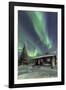 The Northern Lights (Aurora borealis) frame the wooden hut in the snowy woods, Pallas, Yllastunturi-Roberto Moiola-Framed Photographic Print