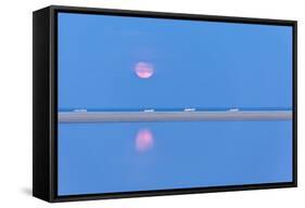 The pink full moon is reflected in the blue water of the Notteri pond, Villasimius, Sardinia, Italy-Roberto Moiola-Framed Stretched Canvas