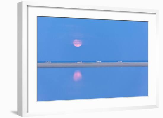 The pink full moon is reflected in the blue water of the Notteri pond, Villasimius, Sardinia, Italy-Roberto Moiola-Framed Photographic Print