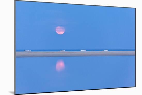 The pink full moon is reflected in the blue water of the Notteri pond, Villasimius, Sardinia, Italy-Roberto Moiola-Mounted Photographic Print