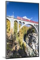 The red train on viaduct surrounded by colorful woods, Cinuos-Chel, Canton of Graubunden, Engadine,-Roberto Moiola-Mounted Photographic Print
