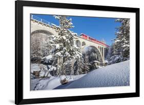 The red train on viaduct surrounded by snowy woods, Cinuos-Chel, Canton of Graubunden, Engadine, Sw-Roberto Moiola-Framed Photographic Print