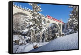 The red train on viaduct surrounded by snowy woods, Cinuos-Chel, Canton of Graubunden, Engadine, Sw-Roberto Moiola-Framed Stretched Canvas