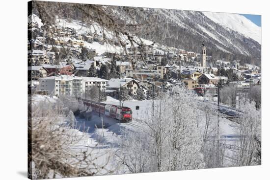 The red train runs across the snowy landscape around Samedan, Maloja, Canton of Graubunden, Engadin-Roberto Moiola-Stretched Canvas