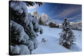 The snowy peak of Sass De Putia frames the wooden hut and woods at dawn, Passo Delle Erbe, Funes Va-Roberto Moiola-Stretched Canvas