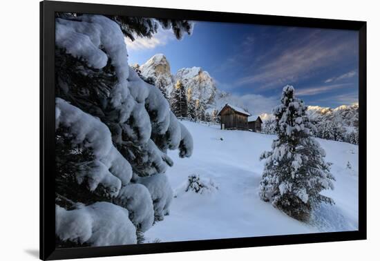 The snowy peak of Sass De Putia frames the wooden hut and woods at dawn, Passo Delle Erbe, Funes Va-Roberto Moiola-Framed Photographic Print