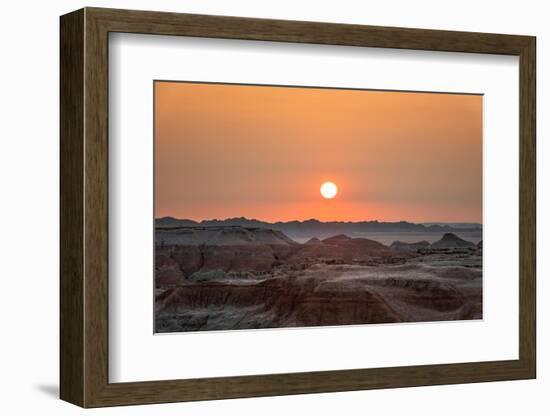 The sun setting over the landscape of hoodoos and hills of Badlands National Park.-Sheila Haddad-Framed Photographic Print