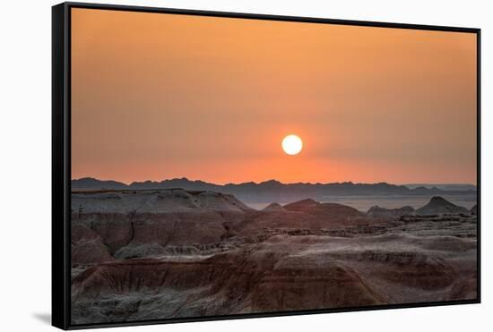 The sun setting over the landscape of hoodoos and hills of Badlands National Park.-Sheila Haddad-Framed Stretched Canvas