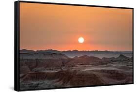 The sun setting over the landscape of hoodoos and hills of Badlands National Park.-Sheila Haddad-Framed Stretched Canvas