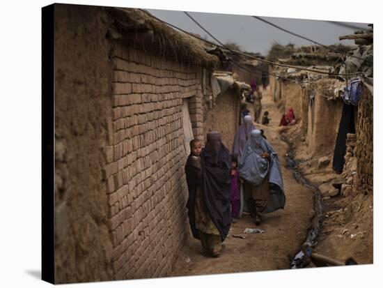 Three Afghan Refugee Women and their Children Walk in an Alley of a Poor Neighborhood in Pakistan-null-Stretched Canvas