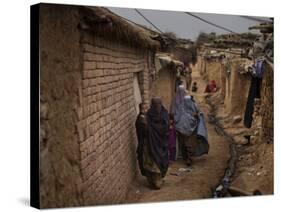 Three Afghan Refugee Women and their Children Walk in an Alley of a Poor Neighborhood in Pakistan-null-Stretched Canvas