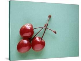 Three Cherries on a Green Background-Karen M^ Romanko-Stretched Canvas