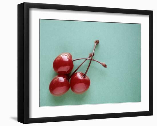 Three Cherries on a Green Background-Karen M^ Romanko-Framed Premium Photographic Print
