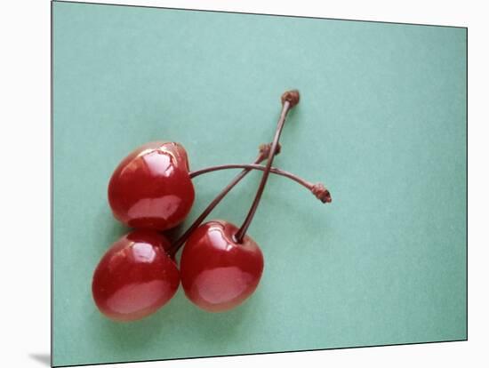 Three Cherries on a Green Background-Karen M^ Romanko-Mounted Photographic Print