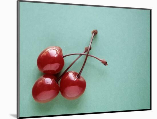 Three Cherries on a Green Background-Karen M^ Romanko-Mounted Photographic Print