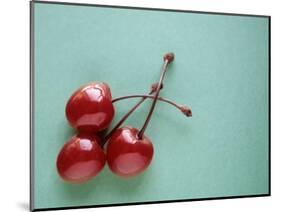 Three Cherries on a Green Background-Karen M^ Romanko-Mounted Photographic Print