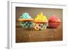 Three Different Colors Cupcakes On A Wooden Table, Blue, Yellow And Pink-pink candy-Framed Art Print