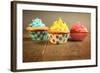 Three Different Colors Cupcakes On A Wooden Table, Blue, Yellow And Pink-pink candy-Framed Art Print