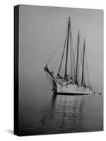 Three-Masted Schooner, Sails Furled, on the Water with a Dinghy in Tow-Bernard Hoffman-Stretched Canvas