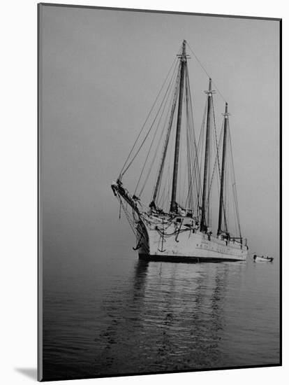 Three-Masted Schooner, Sails Furled, on the Water with a Dinghy in Tow-Bernard Hoffman-Mounted Photographic Print