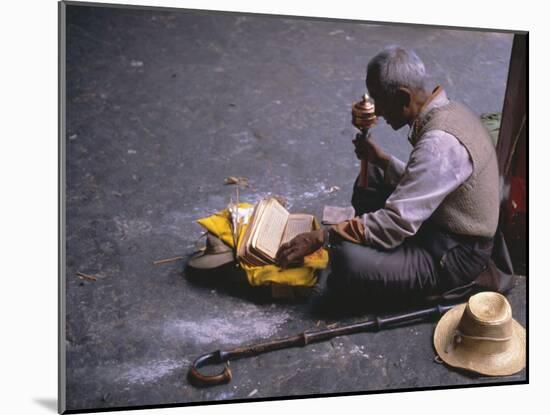 Tibetan Buddhist Pilgrim Reading Texts and Holding Prayer Wheel, Lhasa, China-Alison Wright-Mounted Photographic Print