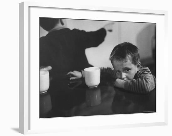 Tired Child is Ready to Go to Sleep with His Head on the Dining Room Table at Ellis Island-Alfred Eisenstaedt-Framed Photographic Print