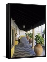 Tourist on Terrace with Striped Cobblestone Floor and Planters, Portugal-Merrill Images-Framed Stretched Canvas