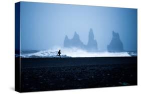 Tourist running on Black Sand Beach, Iceland, Polar Regions-John Alexander-Stretched Canvas